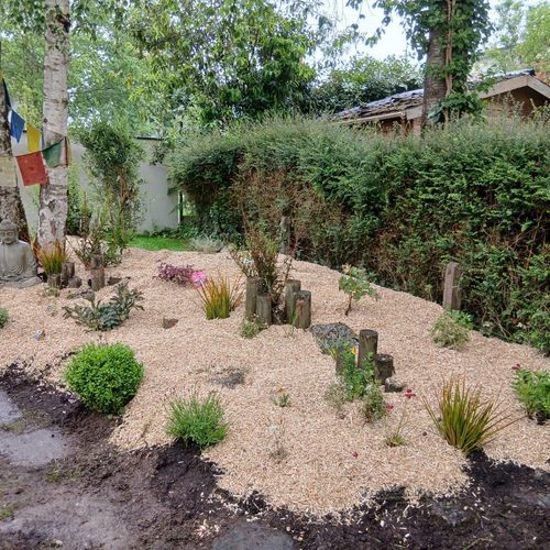 Massif paillé de gravier clair après plantation de vivaces et de petits arbustes